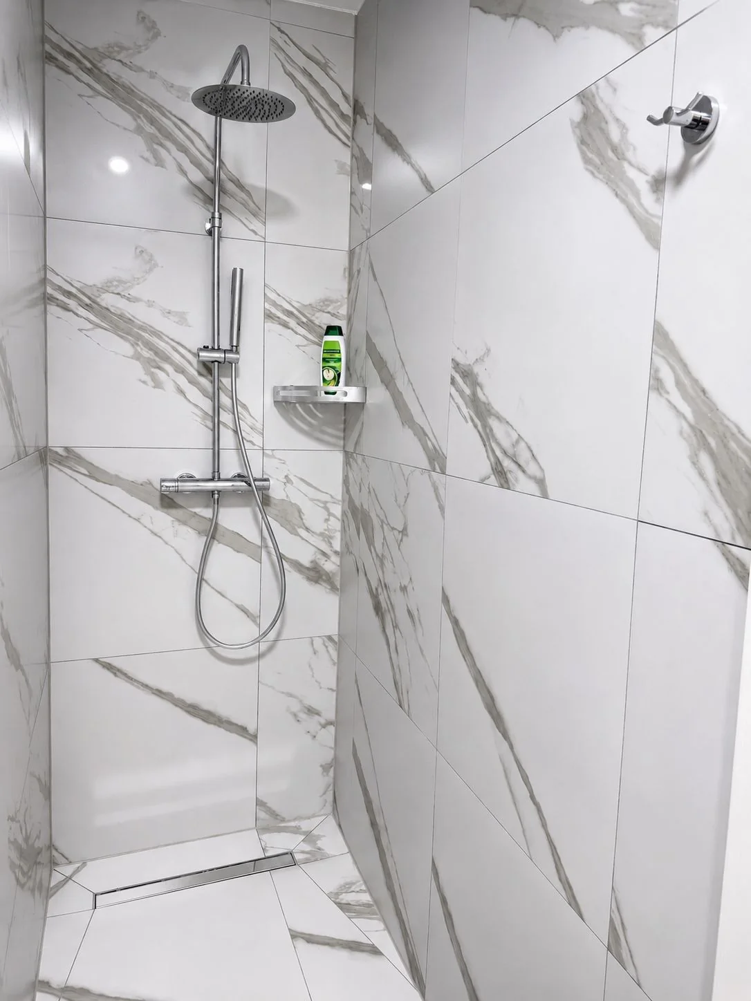 Walk-in shower with rainfall shower head and marble-effect tiling