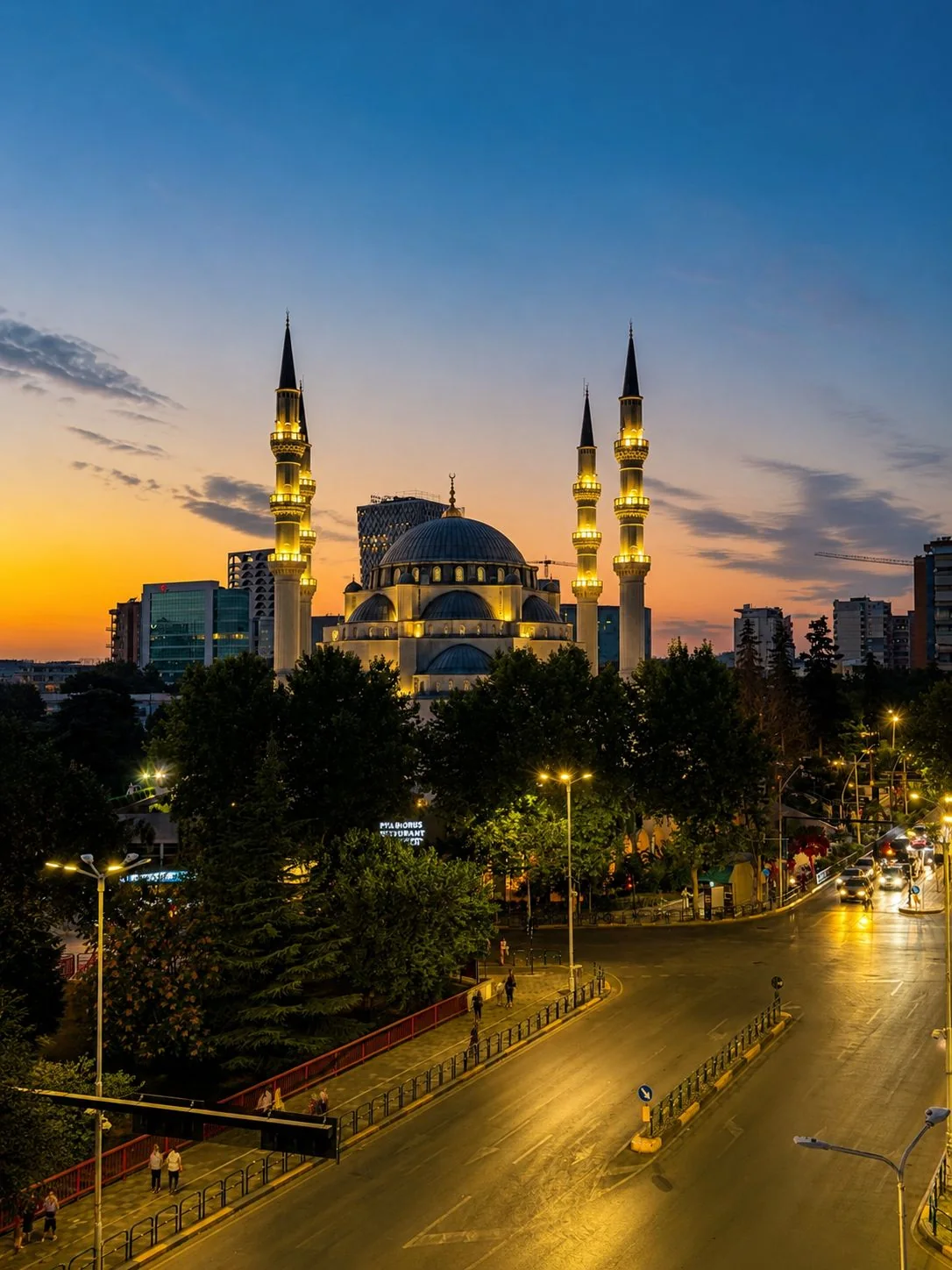 Tirana at sunset with the illuminated Namazgah Grand Mosque and the city skyline